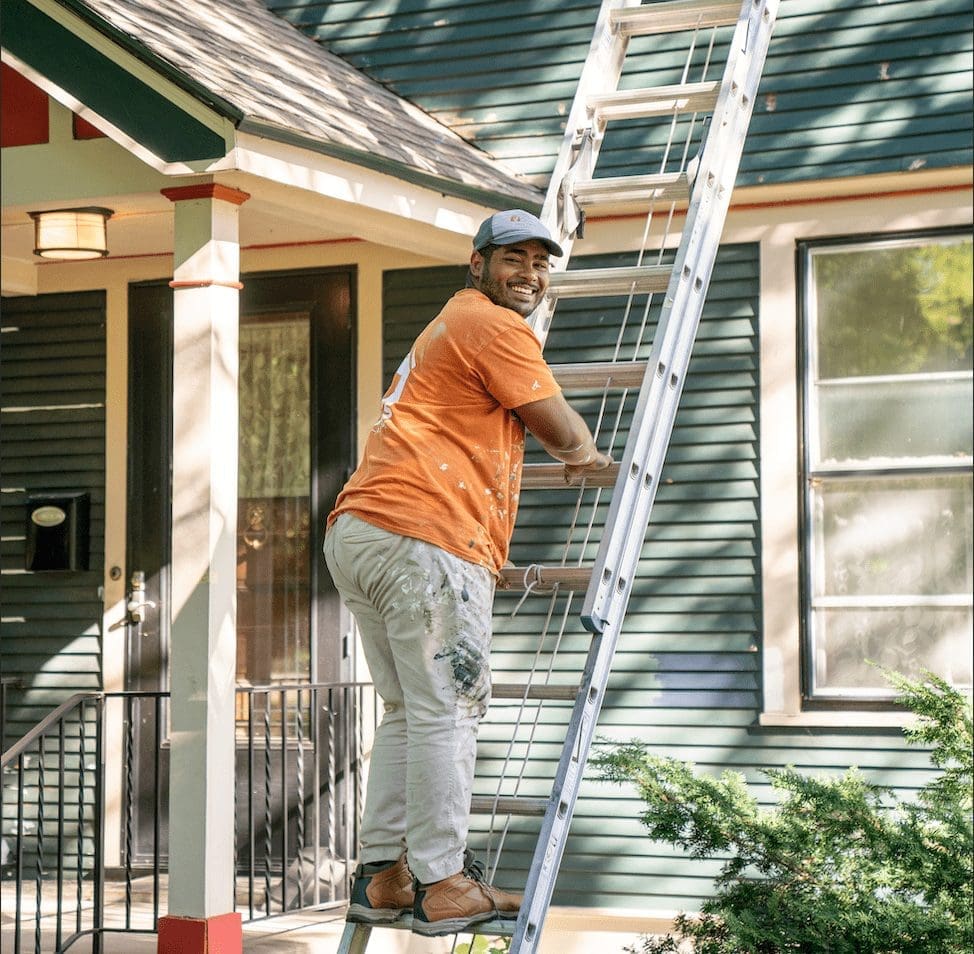 A man on a ladder painting