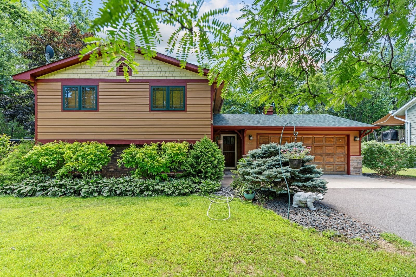 Cedar-sided home in White Bear Township re-stained with red trim